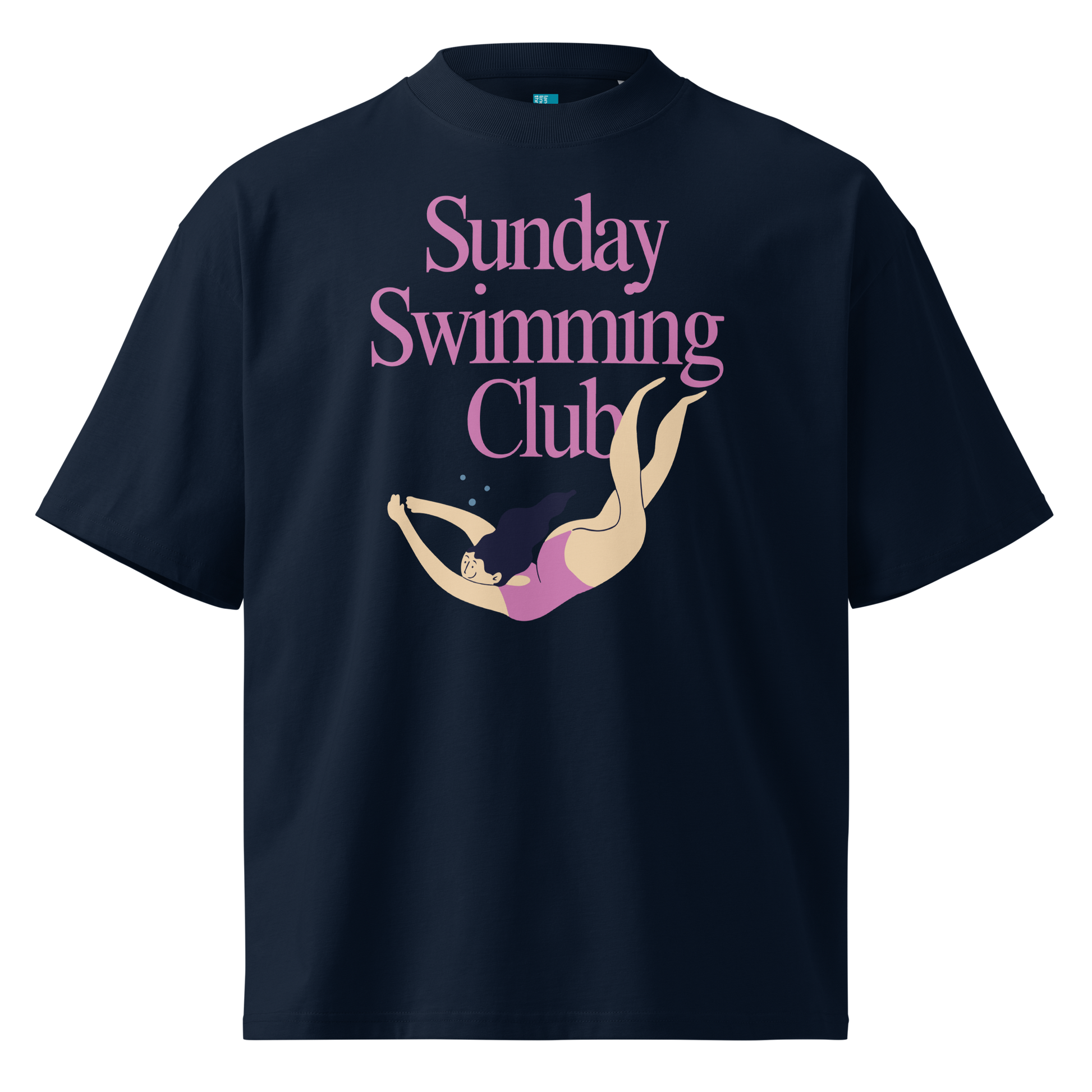 A navy blue organic oversized t-shirt with a graphic print on the front that reads 'Sunday Swimming Club' in pink text above an illustration of a woman diving underwater in a pink swimsuit.