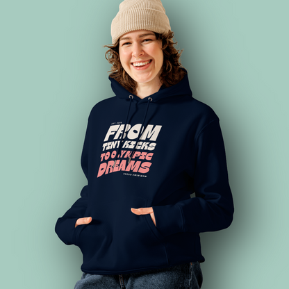 Person wearing a navy swim mom organic hoodie with “From Tiny Kicks to Olympic Dreams – Proud Swim Mom” text in white and pink; 100% organic certified cotton for eco‑conscious swim families.
