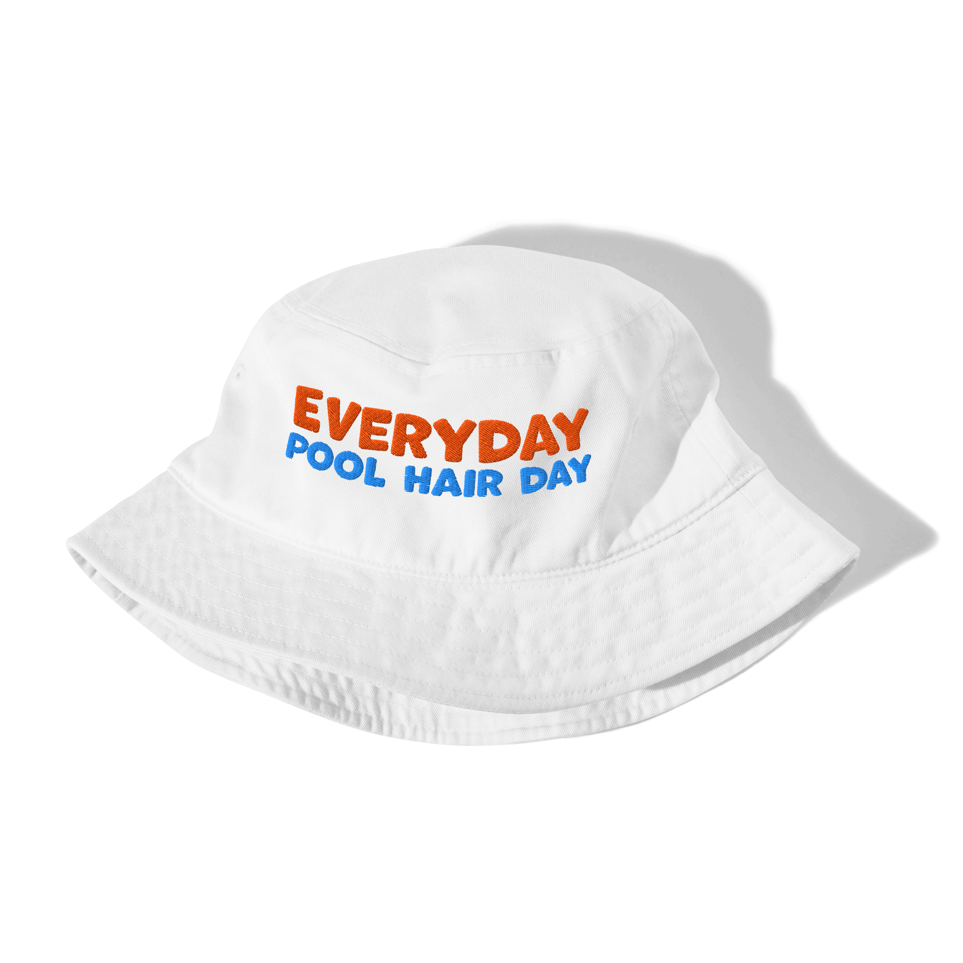 White folded organic cotton bucket hat with "EVERYDAY" in orange and "POOL HAIR DAY" in blue embroidered text. Eco-friendly, breathable, and biodegradable swimmer hat.