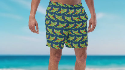 Men wearing organic swim trunks with green zombie sharks' pattern staying on the beach Infront of the ocean