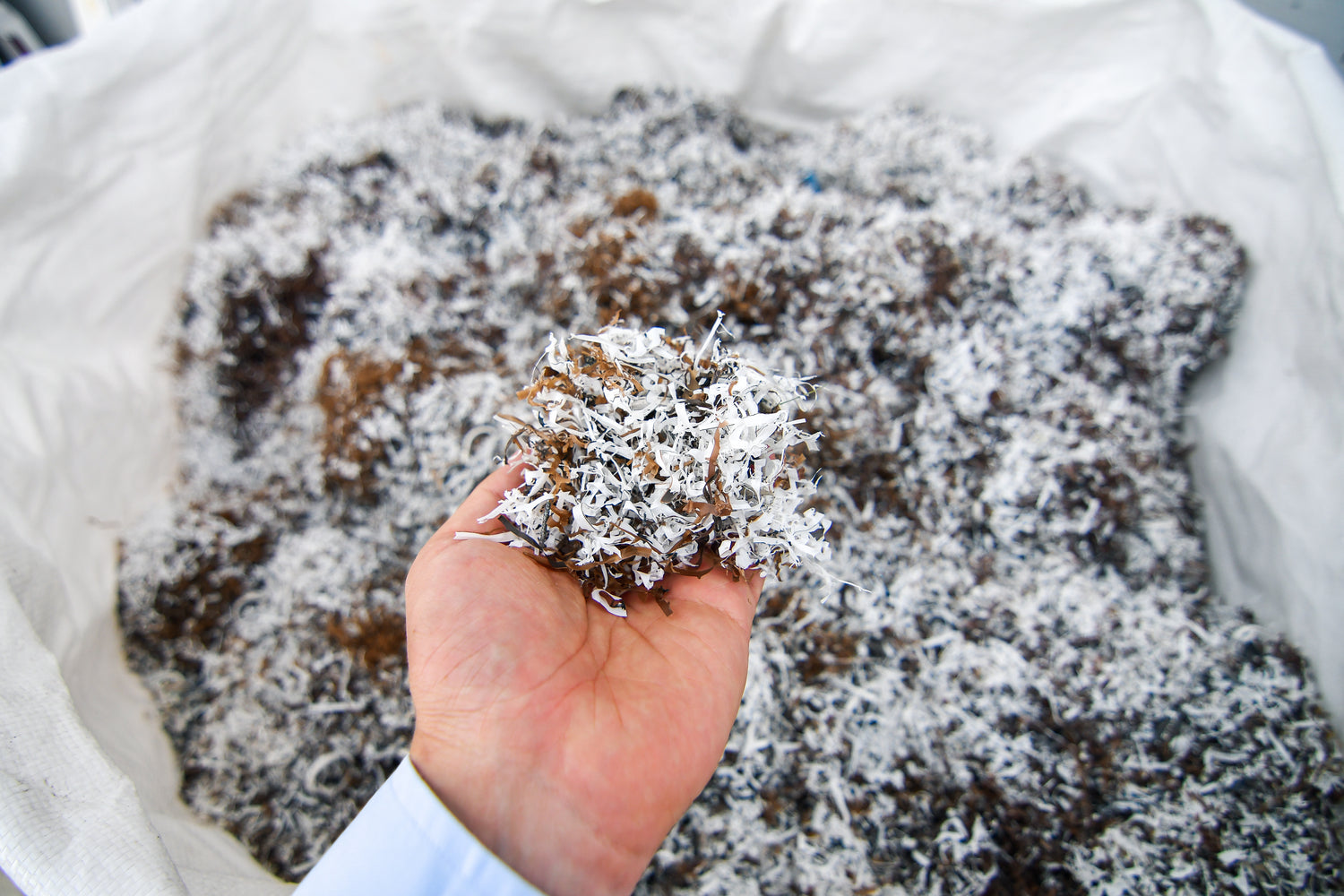 a mans hand full of recycled polyester chips