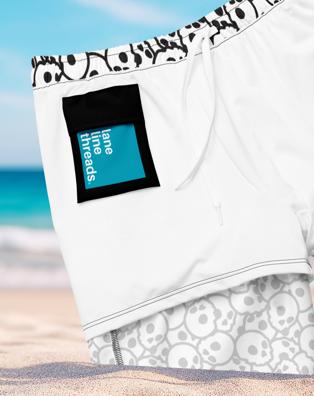 Inner side of an organic swim trunks with a Lane Line Threads brand label on a beach