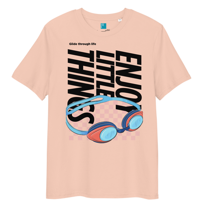 fraiche peche eco-friendly t-shirt featuring vibrant blue and red swimming goggles with a checkered background, and bold black text "ENJOY THE LITTLE THINGS" rotated vertically. Above the goggles, "Glide through life" is in smaller text. Made from 100% organic cotton, this breathable and biodegradable shirt is perfect for competitive swimmers who value comfort, performance, and sustainability. Ideal gift for swim meets or lane-protecting athletes with a sense of humor.
