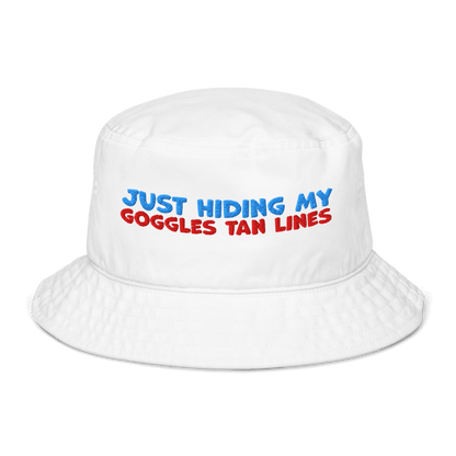 White organic bucket hat with blue and red embroidery reading “Just Hiding My Goggles Tan Lines.” Eco-friendly, breathable, and biodegradable swimmer hat.