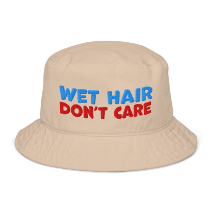 Beige organic cotton bucket hat with "WET HAIR" in blue and "DON'T CARE" in red embroidered text.